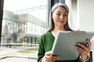 Attractive smiling mature woman with long gray hair standing