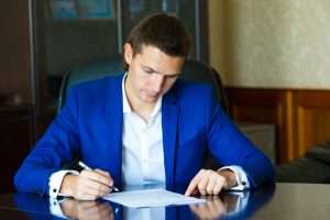 Business man signing a contract in big office
