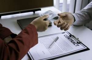Business woman giving money to bribe an employee of a financial company So that the company's illega