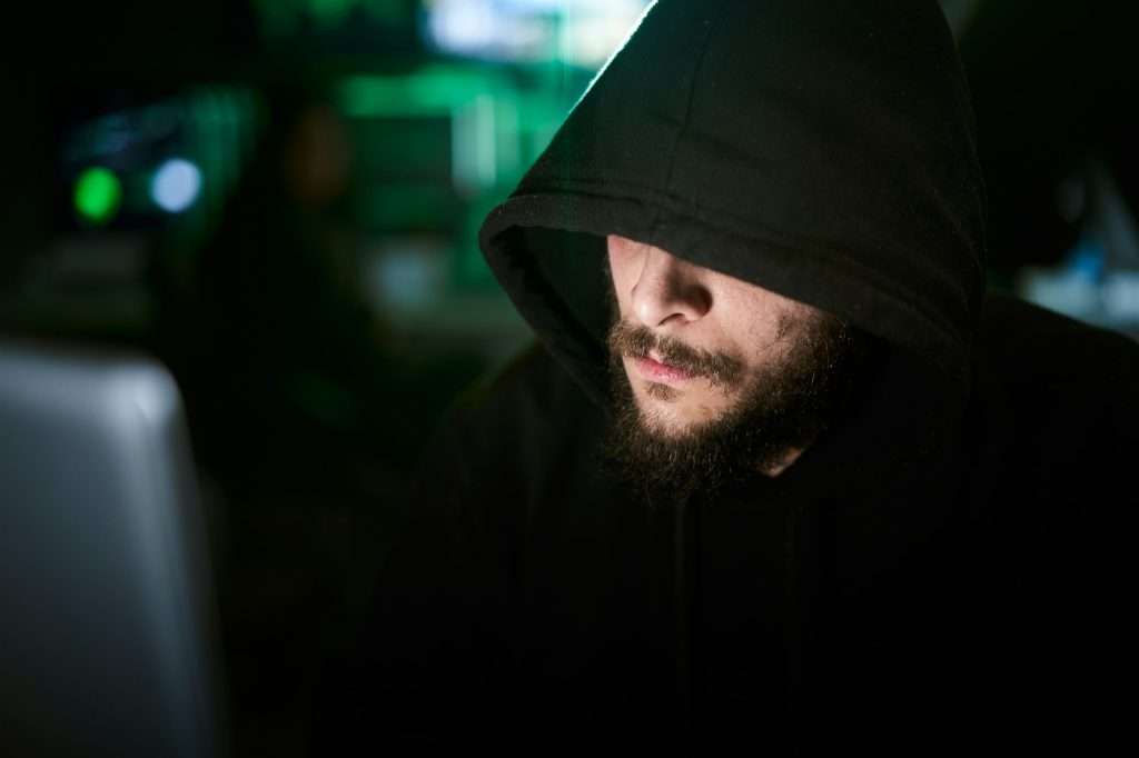 Criminal team Hacker using computer for organizing massive data breach attack