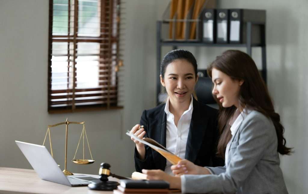 Female Lawyer Litigation Trial Lawyer office. Statue of Justice with scales and lawyer working on a