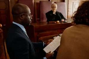 Focus on young confident attorney reading juridical document in court