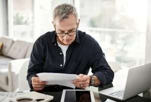 His eyes never miss the fine print. Shot of a mature man going through some paperwork at home.