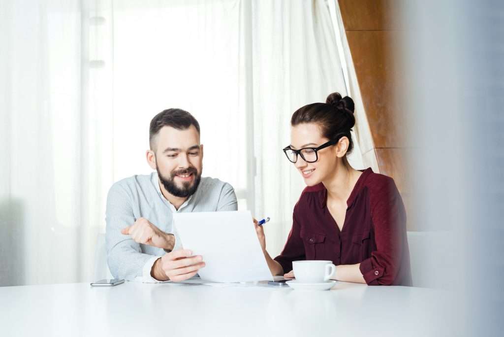 Two happy businesspeople discussing new project in meeting room