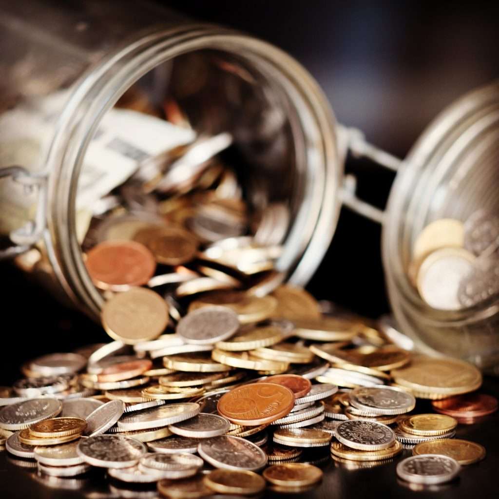 A jar of coins tipping over representing the varying GST/HST rates charged on Ontario legal services depending on the client's location and the type of legal work
