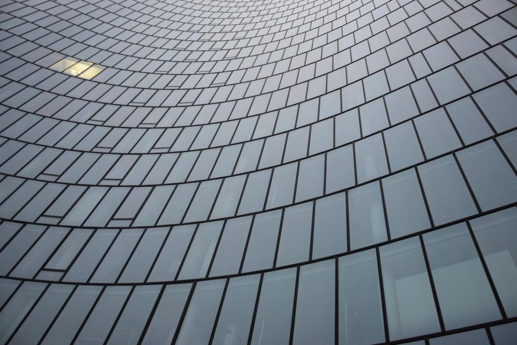 Curved glass facade of an office tower, in black and white